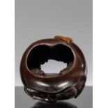 NETSUKE OF A POMEGRANATE WITH INTERIOR CARVING OF A COUPLE