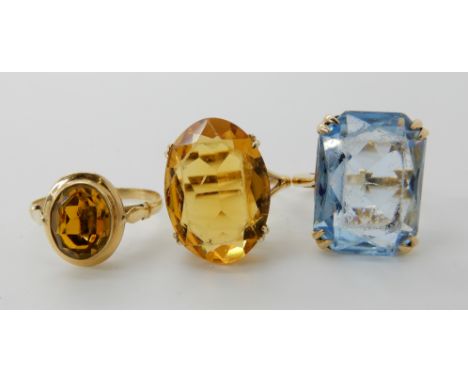 A 9ct yellow gem ring size M1/2, a 9ct blue gem ring, size M1/2, and a yellow metal yellow gem set ring size O, combined weig