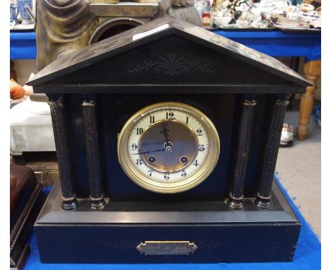 A black slate mantel clock of architectural form, with brass plaque inscribed 'Presented to Mr Jas. Dalton on his leaving the