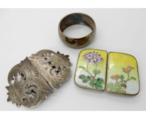 An Oriental flower enamelled buckle, decorative EPNS buckle and a silver serviette ring Condition Report: Not available for t