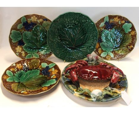 A Palissy style majolica crab decorated wall plaque, 26cm diameter together with four grape and vine leaf decorated plates, t