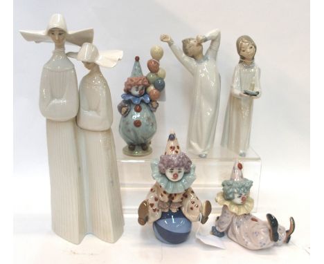 A Lladro figure group of two nuns, two Lladro figures of children in nightgowns and a set of three clowns (one with balloons 