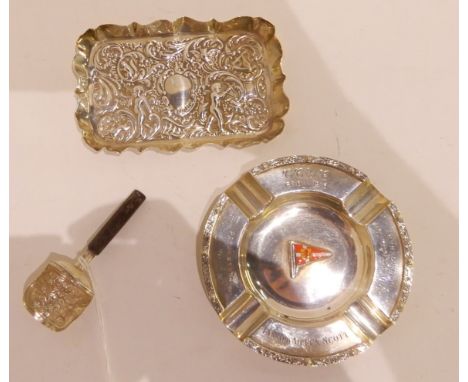 A lot comprising a white metal ashtray, an embossed silver dish, London 1900 and a silver caddy spoon, unknown marks (3) Cond