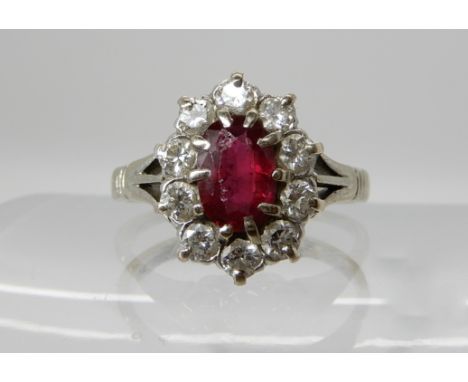 An 18ct and platinum ruby and diamond cluster ring, ruby approx 7mm x 5mm, diamonds estimated approx combined 0.40cts, approx