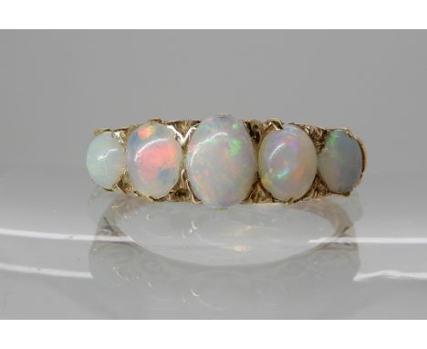 A yellow metal ring set with five white opals, largest opal approx 6.5mm x 4.5mm, finger size S, weight 3gms Condition Report