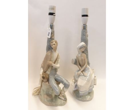 A pair of Nao figural lamp bases, modelled as a shepherd and a woman with sheep, 37cm high (2) Condition Report: Available up