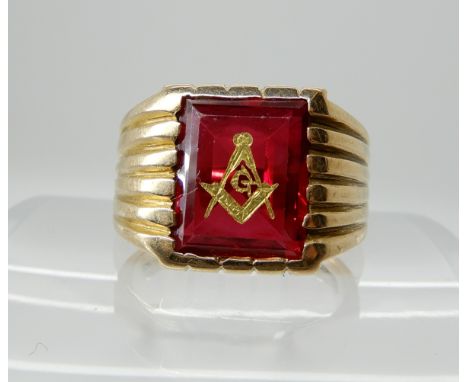 A 10k gold ring set with a red glass gem inscribed with a Masonic symbol, size T1/2, weight 9.8gms Condition Report: Mount me