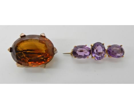 A 9ct gold three stone amethyst brooch, length 3cm, together with a yellow metal citrine set brooch 2.6cm, weight of both tog