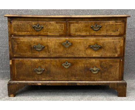A mid Georgian walnut and featherbanded chest of three long drawers on bracket feet. Possibly with all original brassware. H.