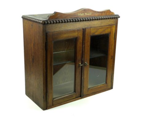 A mid 20th century oak and glazed cigarette / tobacco advertising shop display cabinet, with brand name 'Gold Flake' printed 