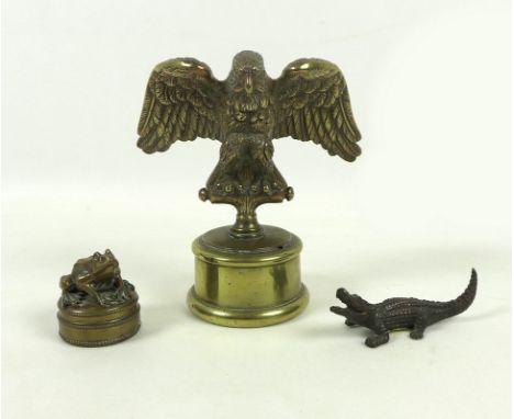 An Edwardian brass car mascot, in the form of an eagle perched on a T bar with wings outstretched, 15cm high, a frog trinket 