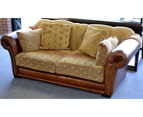 A contemporary leather and fabric two seat sofa.