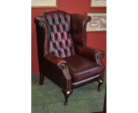 An executive office ox blood leather button upholstered wingback armchair.