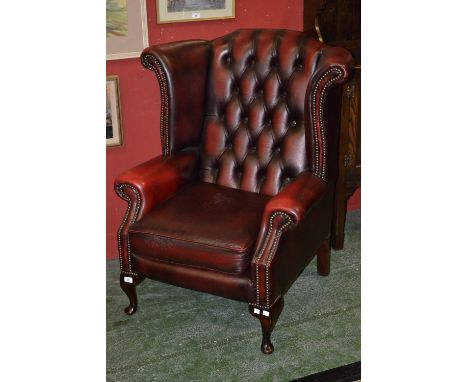 An executive office ox blood leather button upholstered wingback armchair.