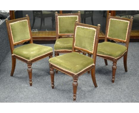 Four carved oak dining chairs, fluted button finials, harebell carved uprights, padded back and seat, turned carved and taper