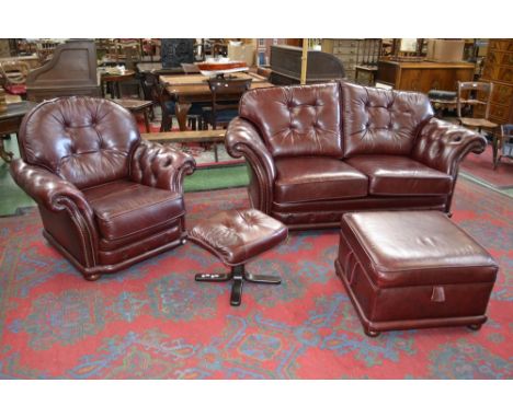 A late 20th century oxblood leather four piece suite, comprising a button upholstered two seater sofa, conforming armchair, p