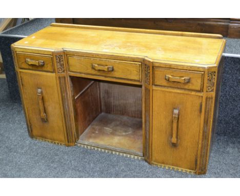 A 1940's light oak inverted breakfront sideboard, long drawer flanked short over recess and cupboards.