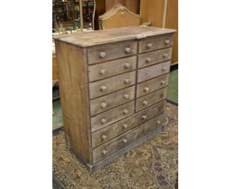 An unusual pine chest of ten short drawers over two long, button handles, plinth base, circa 1900. 116cm high x 111cm wide x 