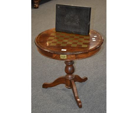 A contemporary walnut games table, circular top, inlaid brass checkers board, baluster turned column, cabriole legs; a resin 
