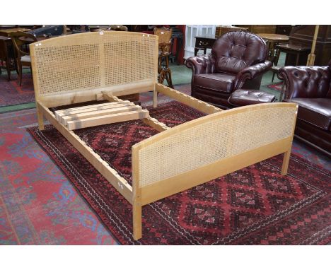 A contemporary light oak double bed with wickerworked head and footboards.