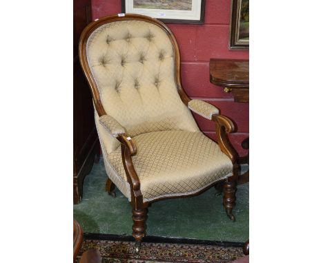 A Victorian walnut button upholstered spoonback armchair, padded arms, scrolling terminals, stuffed overseat, turned forelegs
