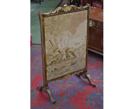 A French style mahogany gilt decorated firescreen, seashell and scrolling foliate pediment, woolwork, shepherd and his flock.