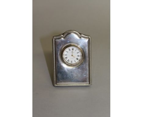 A SILVER CASED CLOCK. 3.5ins high. 