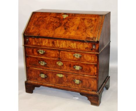 AN 18TH CENTURY WALNUT BUREAU with fall flap enclosing pigeonholes, small drawers and a well, above three graduated long draw