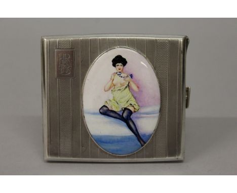 A GEORGE V SILVER ENGINE TURNED CIGARETTE CASE with an oval of a semi nude in black stockings. Birmingham 1930. 