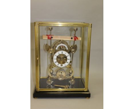 A GOOD BRASS SKELETON CLOCK with white enamel dial, black and white Roman numerals, contained in a glass case on stand. 17ins
