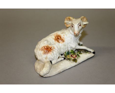 AN 18TH CENTURY DERBY PATCH MARKED MODEL OF A RAM reclining on a floral encrusted mound, tail and ear repaired.