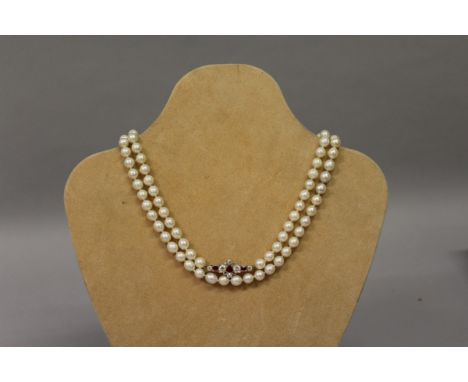 A SUPERB LONG PEARL SINGLE STRAND OF ONE HUNDRED AND SIX PEARLS with ruby and diamond set clasp. 