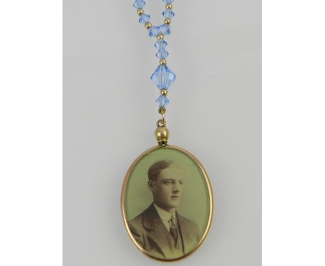 A yellow metal framed double portrait pendant, suspended on a blue crystal necklace, the yellow metal clasp stamped 375.