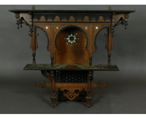 A late 19th century North African hard wood hanging shelf, inlaid with mother of pearl, having a carved pediment above a mihr