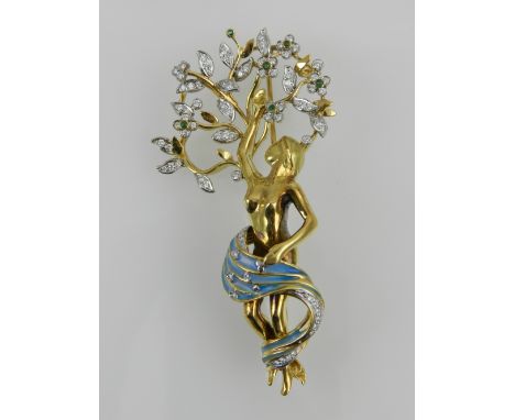 Puig Doria. A yellow metal, diamond, and enamel brooch, formed as a female nude beneath a tree, possibly Daphne, the tree dec