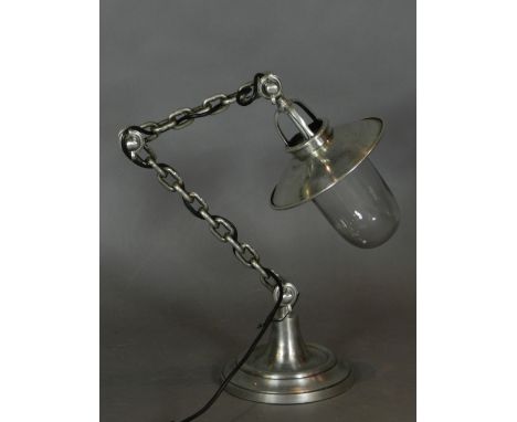 An unusual desk lamp, chrome plated and raised on a circular spreading base.