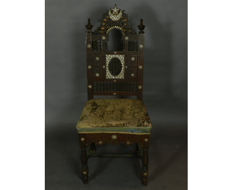 A North African carved hardwood and mother of pearl inlaid dining chair, having a tapestry woven upholstered seat decorated w