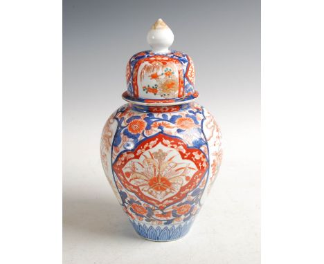 A Japanese Imari jar and cover, Meiji Period, decorated with shaped panels of urn issuing peony and scholar with attendant bo