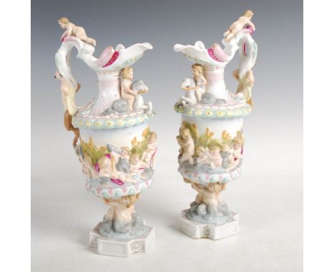 A pair of Sitzendorf porcelain Renaissance style ewers, modelled with putti and satyr handles, blue painted marks, 31cm high.