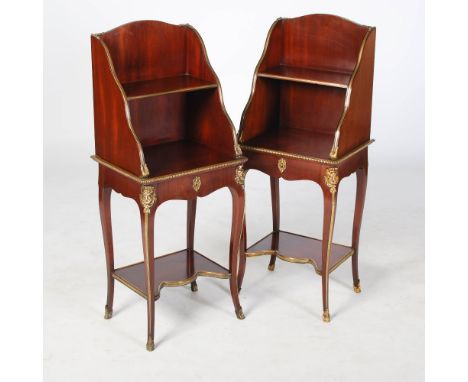 A pair of mahogany and gilt metal mounted waterfall type bookcase occasional tables, BERTRAM & SON, the arched backs enclosin