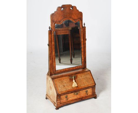 An 18th century walnut dressing table mirror, with hinged mirror plate above a fall front opening to a fitted interior of pig