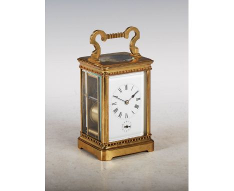 A late 19th century brass striking carriage clock with alarm, the white enamel dial with Roman numeral dial and Arabic numera