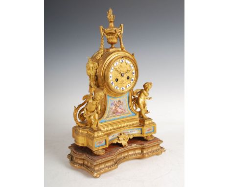 A late 19th century French ormolu and porcelain mounted mantle clock, the circular dial with individual Roman numeral panels,