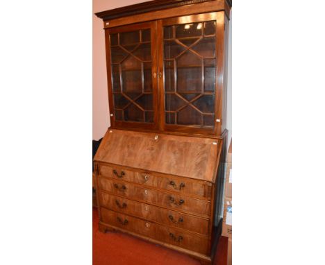 A George III mahogany bureau bookcase, the moulded cornice and dentil frieze above a pair of astragal glazed cupboard doors, 