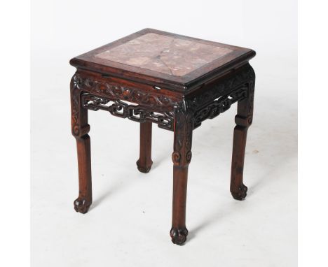 A Chinese dark wood jardiniere stand, Qing Dynasty, the square top with a mottled red and white marble insert, above a foliat