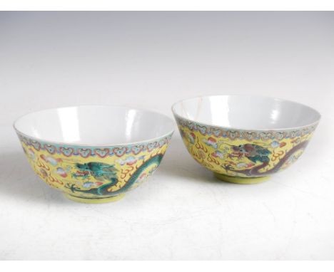 A pair of Chinese porcelain yellow ground bowls, Kangxi six character marks but later, decorated with green and aubergine col