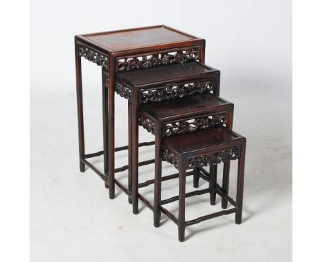 A quartetto of Chinese dark wood occasional tables, the rectangular panelled tops above pierced flowers, foliage and scroll c