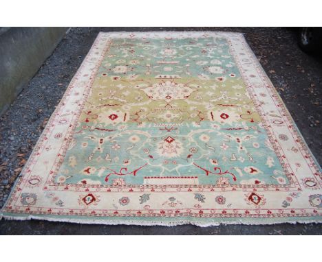 A Persian green ground carpet, 20th century, worked in red coloured threads with a large central flower head surrounded by sc