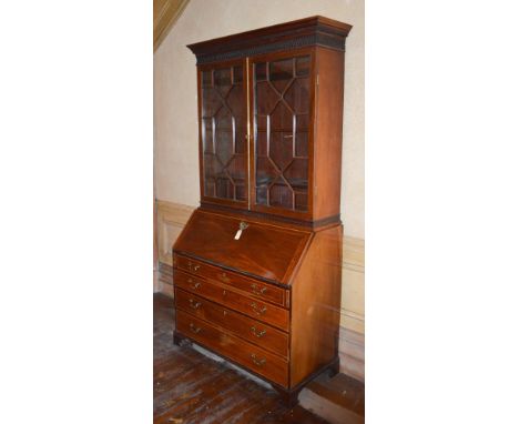 A 19th century mahogany and boxwood lined bureau bookcase, the moulded cornice with dentil frieze above a blind fret work arc