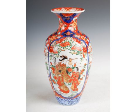 A Japanese Imari vase, late Meiji Period, decorated with panels of figures divided by smaller panels of egrets, on a red grou